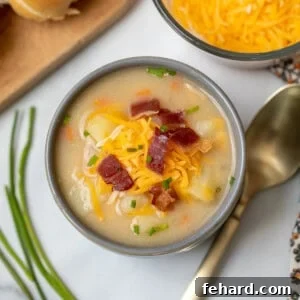 A bowl of creamy potato soup topped with cheese and bacon.