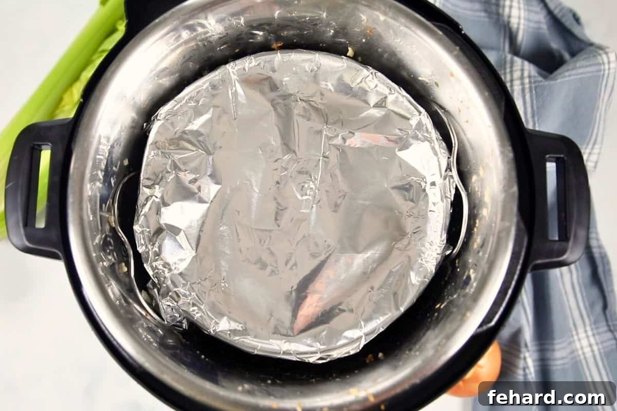 Assembled Instant Pot setup: water in the inner pot, metal trivet in place, and the foil-covered stuffing pan resting securely on the trivet.