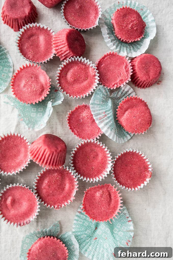 An inviting overhead view of several strawberry coconut butter cups arranged against a clean white background, highlighting their vibrant colors.