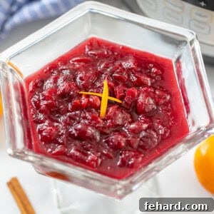 Cranberry sauce topped with orange zest next to the inner pot.