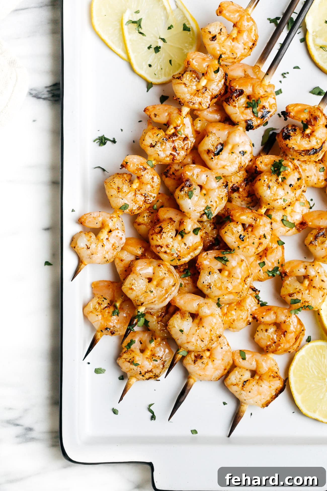 Succulent grilled shrimp on skewers beautifully arranged on a serving platter, ready to be enjoyed with a squeeze of fresh lemon.