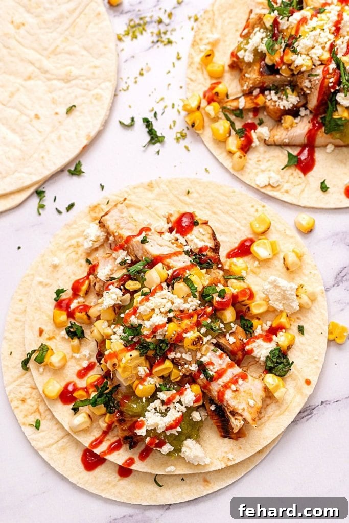 Grilled Honey Lime Chicken Fajita served on a white counter, topped with vibrant corn salsa and fresh salsa verde. The chicken is perfectly charred and juicy.