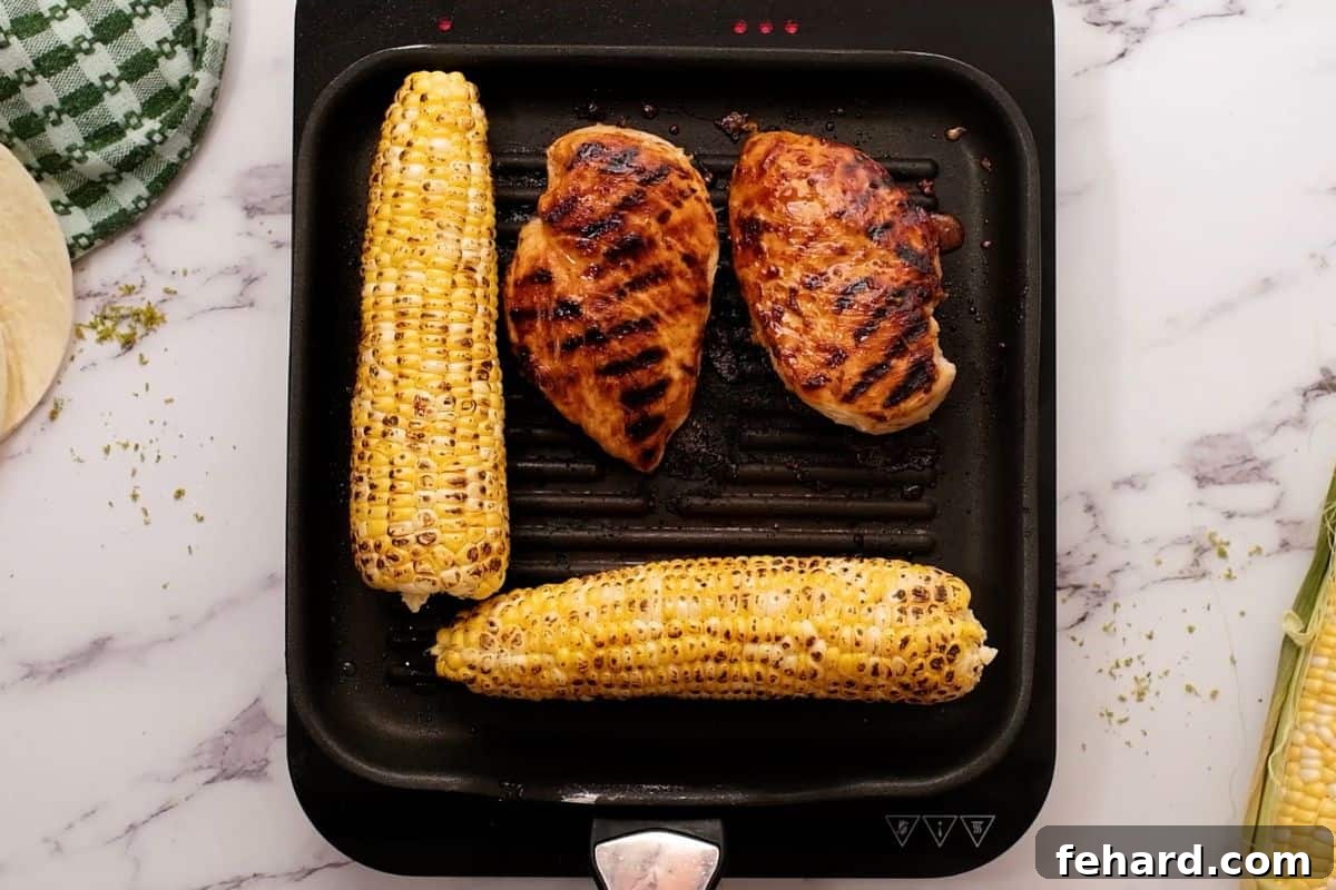 Honey Lime Marinated Chicken and fresh corn on the cob grilling on a grill pan, showing delicious char marks.