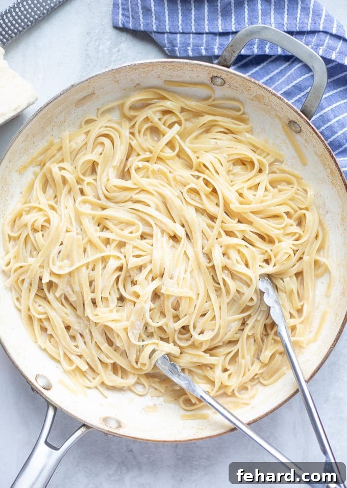 Pan of perfectly cooked fettuccine alfredo, showcasing the creamy light sauce.