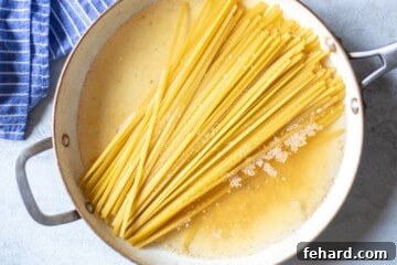 Broth, fettuccine noodles, and garlic in 12-inch skillet.