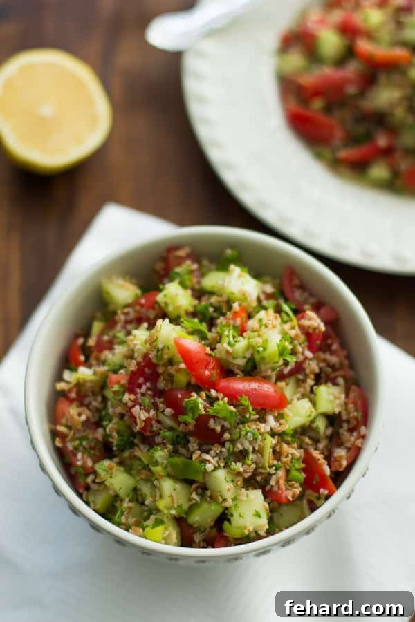 bowl of tabbouleh with bulgur, cherry tomatoes, cucumber, mint, and parsley 