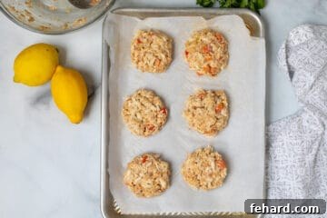 Shaped Crab Cakes on parchment lined baking sheet.