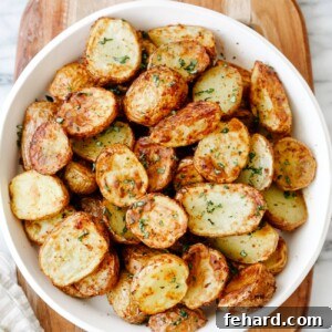 Overhead view of perfectly air-fried baby potatoes served in a white plate, ready to be enjoyed.