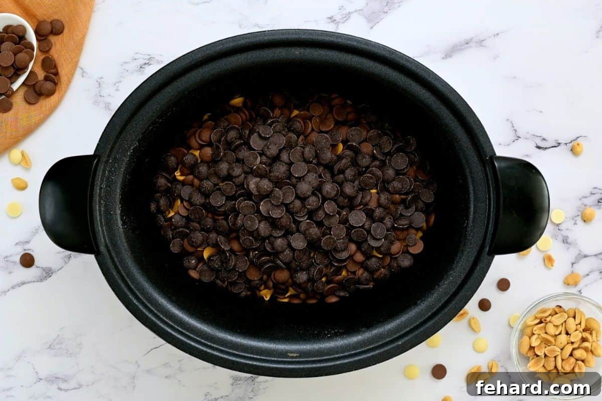 Layered Crockpot Nut Clusters Ingredients Peanuts, peanut butter chips, white chocolate chips, and semi-sweet chocolate chips carefully layered in a slow cooker, ready for melting.