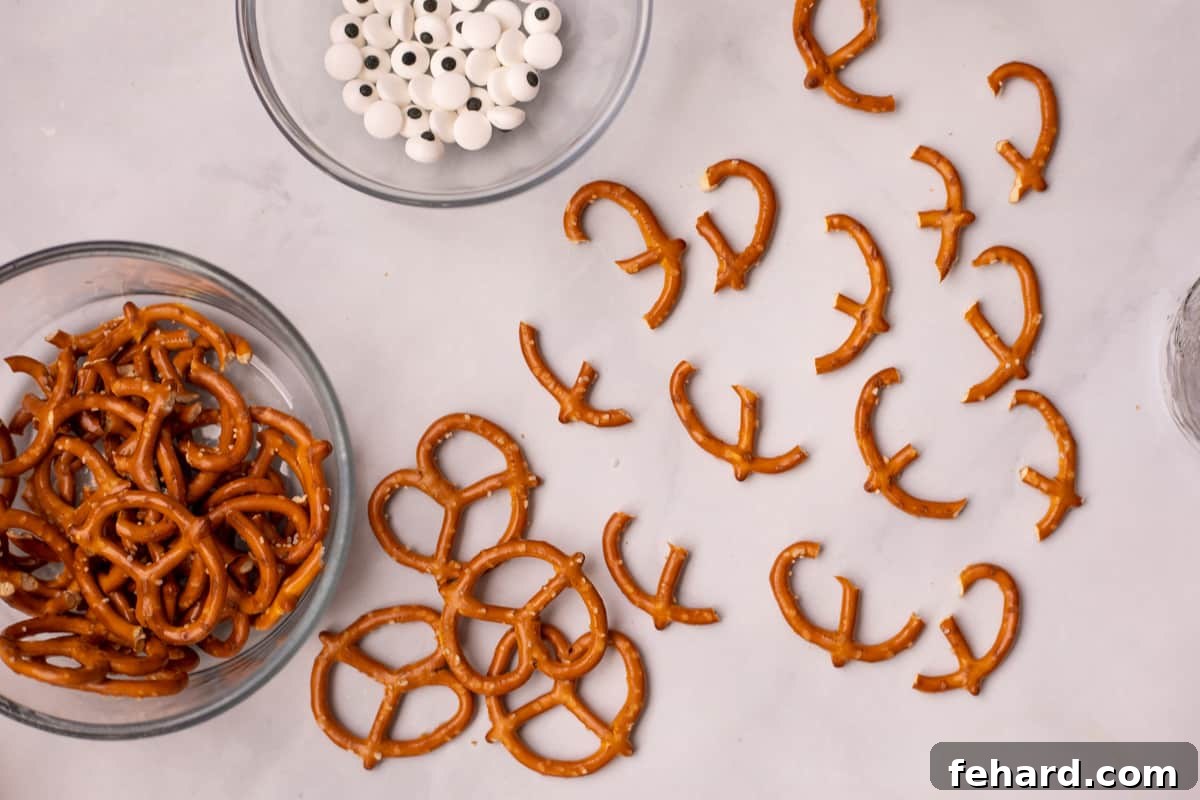 A pretzel twist carefully broken in half on a clean white counter, clearly demonstrating the technique to create distinct reindeer antlers for holiday pretzels.