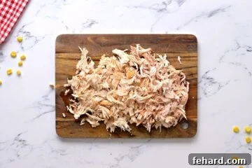 Shredded chicken on cutting board.