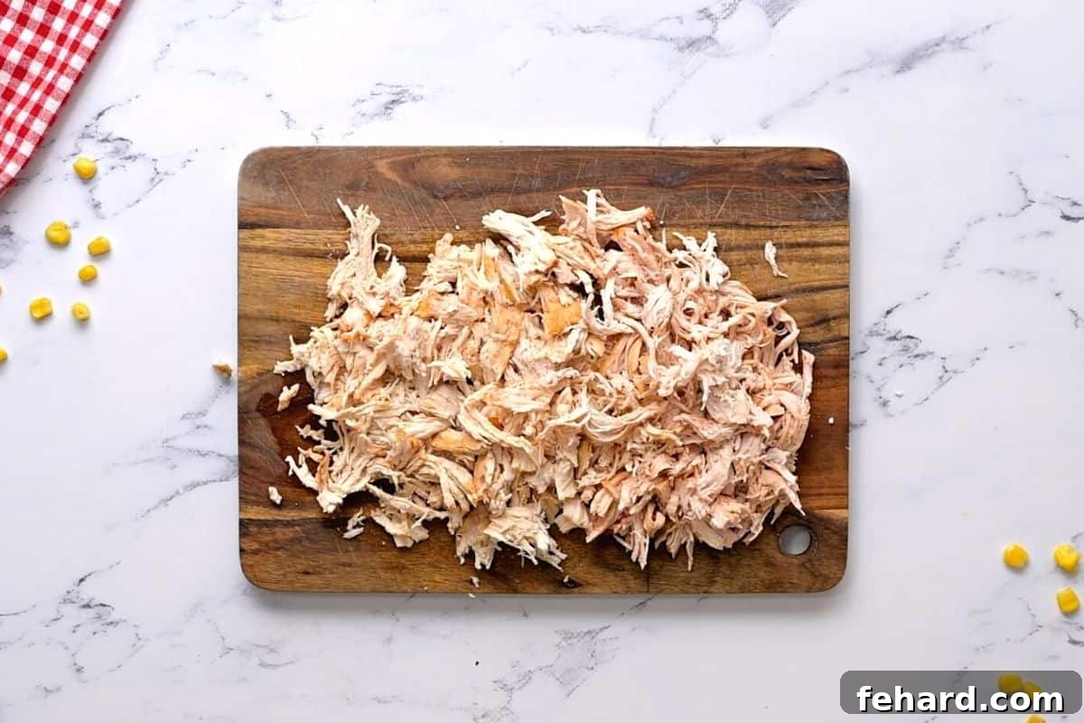 Shredded Chicken on wooden cutting board. 