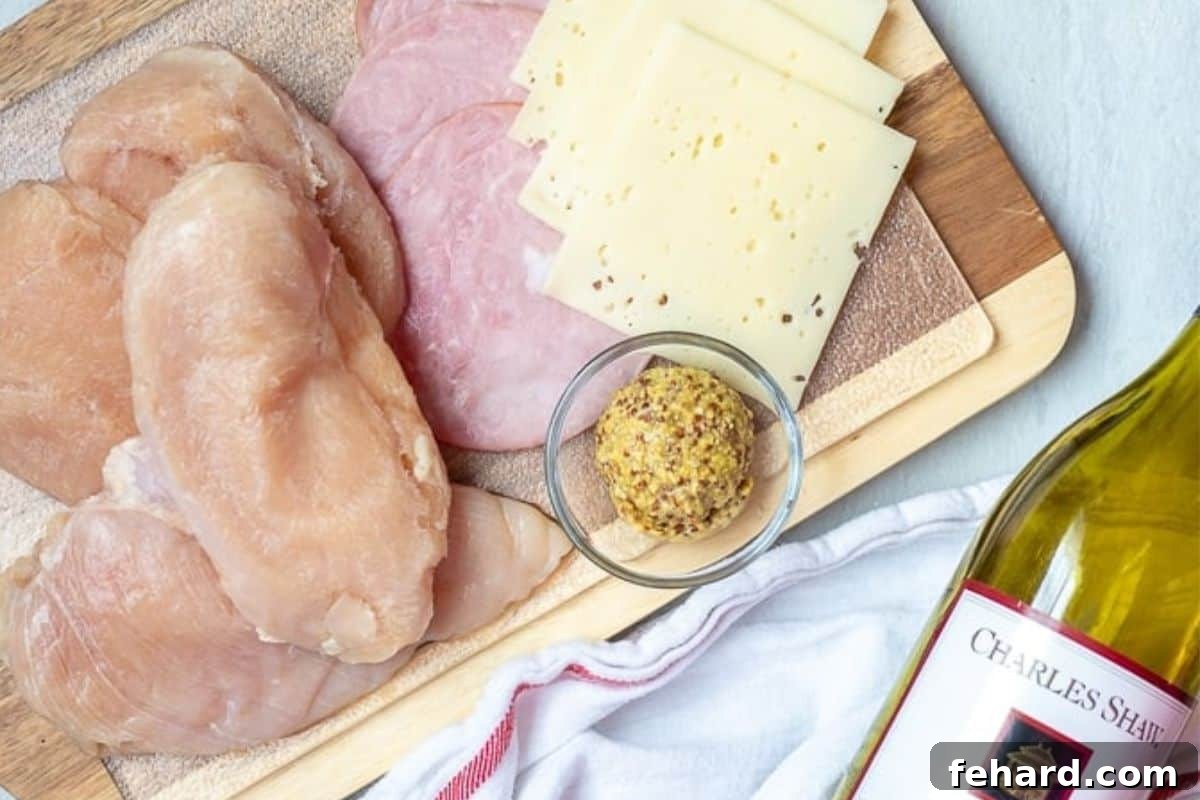 Chicken Breasts, mustard, cheese, and ham on counter for ingredients for making Chicken Cordon Bleu.