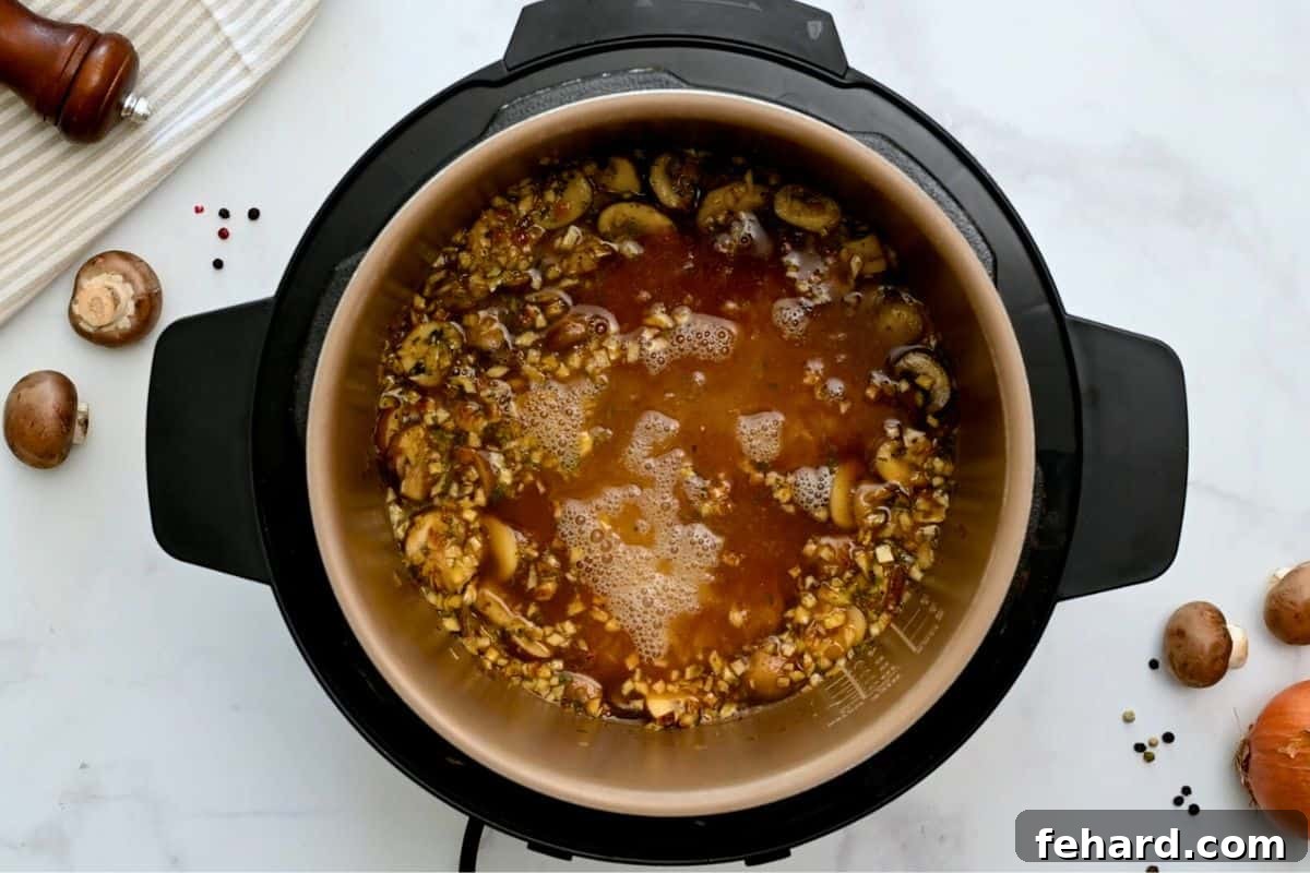 Rinsed rice, mushrooms, garlic, and onions, layered inside Instant Pot before pressure cooking.