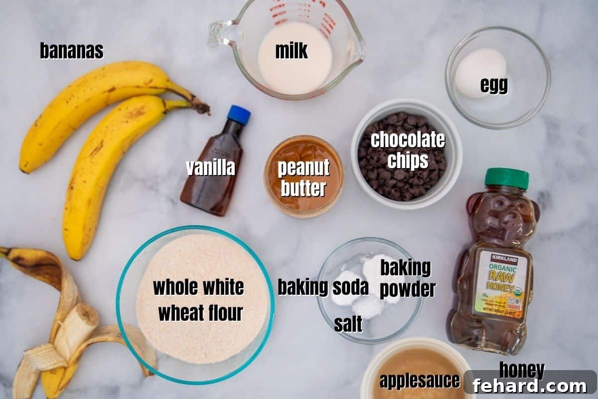 Ingredients for PB Muffins labeled on counter: bananas, peanut butter, applesauce, honey, flour, milk, chocolate chips, and baking essentials.