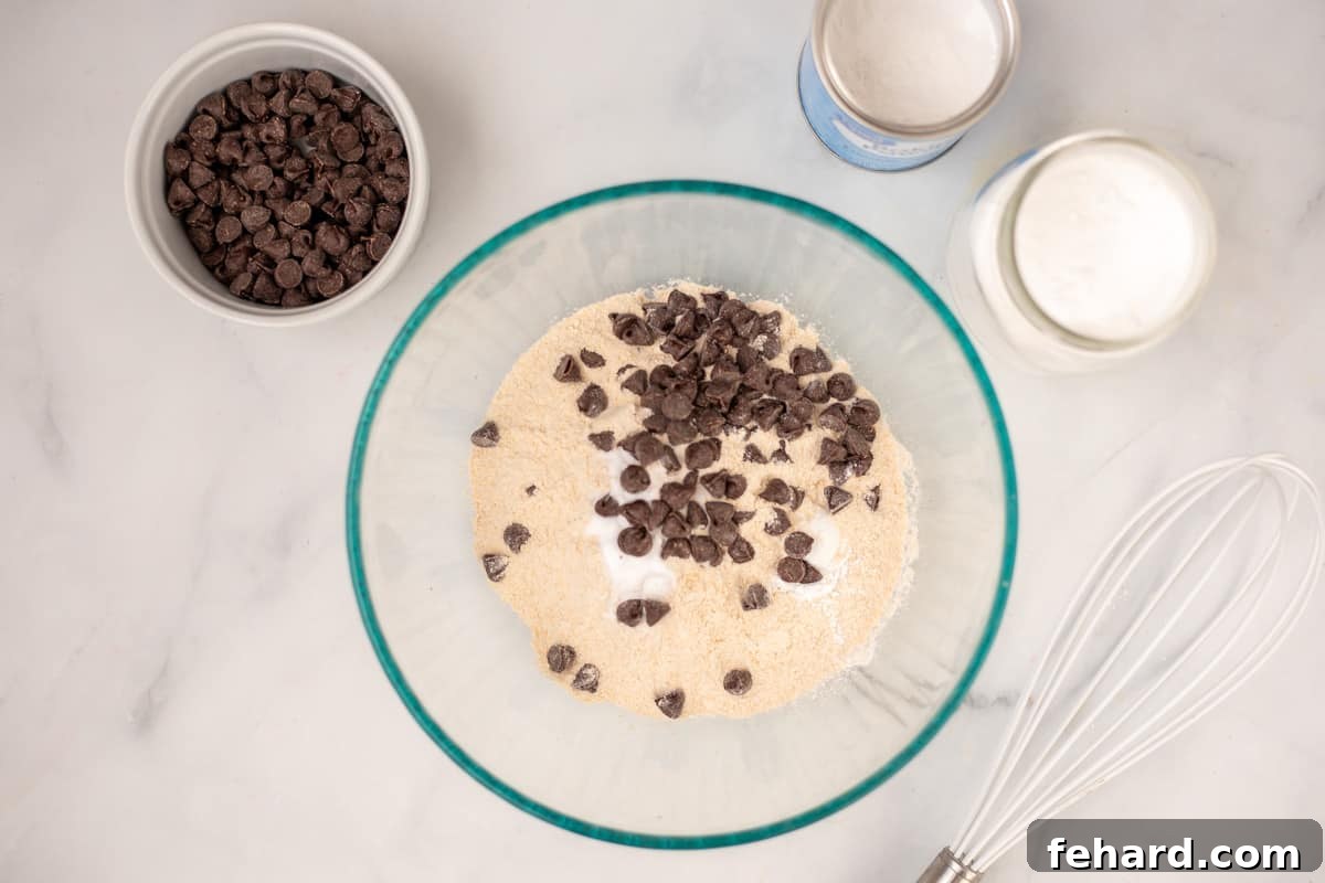Bowl with dry ingredients for peanut butter muffins, including chocolate chips coated in flour.