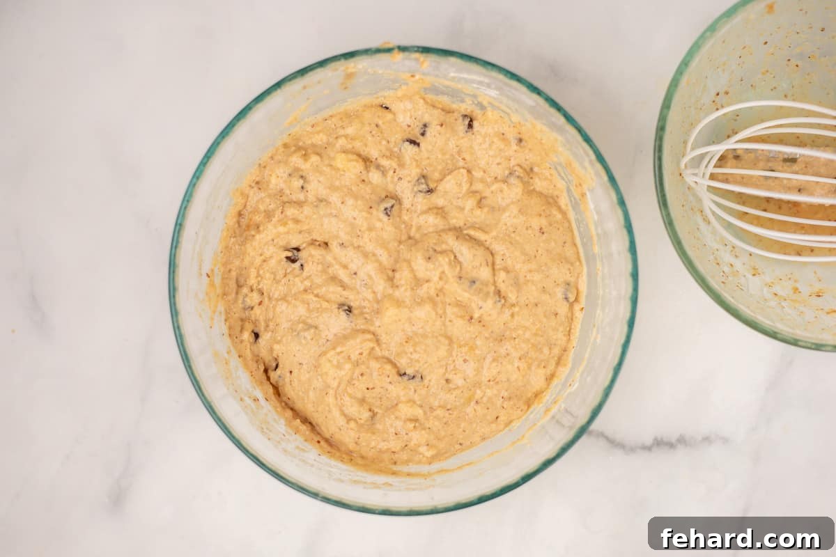 Peanut Butter Banana Muffin Batter in mixing bowl, showing a slightly lumpy, perfectly mixed consistency.