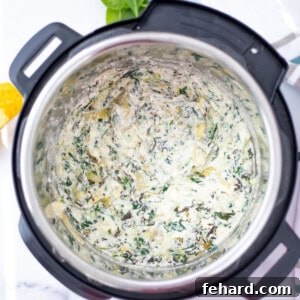 Spinach Artichoke Dip inside inner pot of Instant Pot, showcasing its delicious texture.