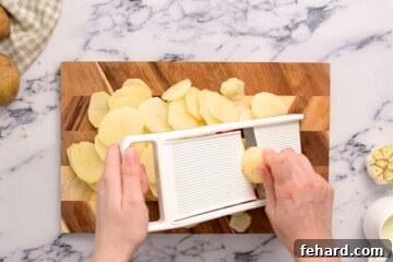 Showing slicing potatoes on a mandoline into thin slices.