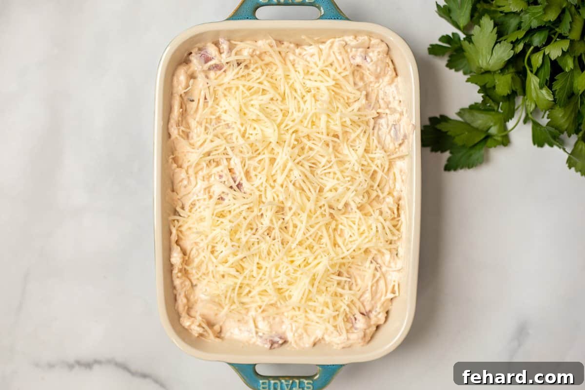 Reuben Dip in casserole dish topped with shredded cheese.