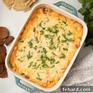 Baked Reuben Dip topped with fresh parsley next to triscuits and rye chips.