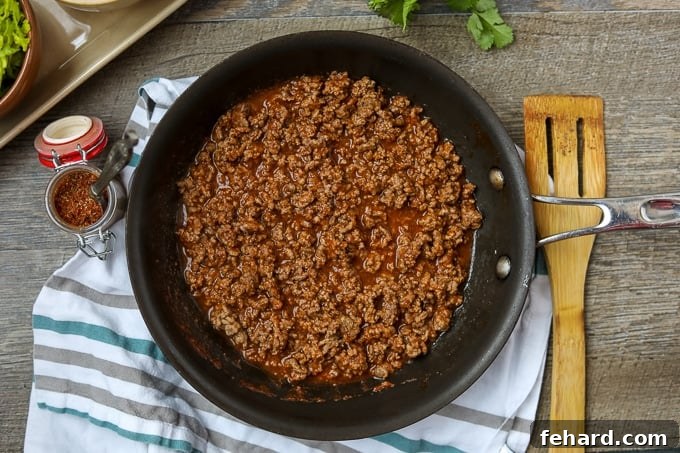 Fully cooked taco meat, glistening with sauce and spices, ready to be served from the skillet.