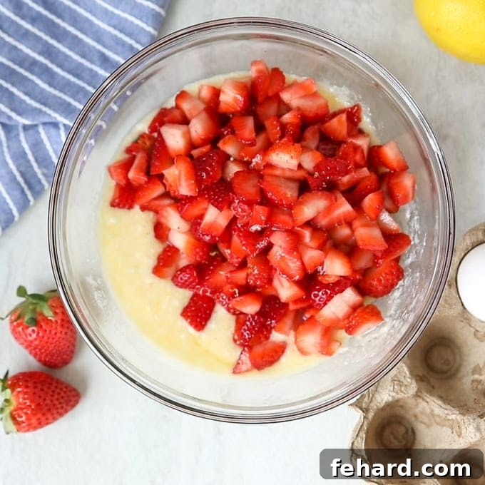 Strawberry Bar Recipe Filling Fresh strawberry filling mixture in a mixing bowl, ready to be poured over the crust.