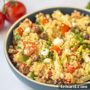 Hellenic Quinoa Medley 3 Greek Quinoa Salad served in blue serving dish with tomatoes in background.