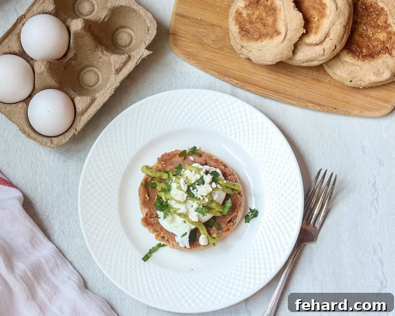 Zesty Tex Mex Benedict Featuring Avocado Hollandaise 3 Two halves of poached egg on whole wheat english muffin with avocado sauce and feta cheese