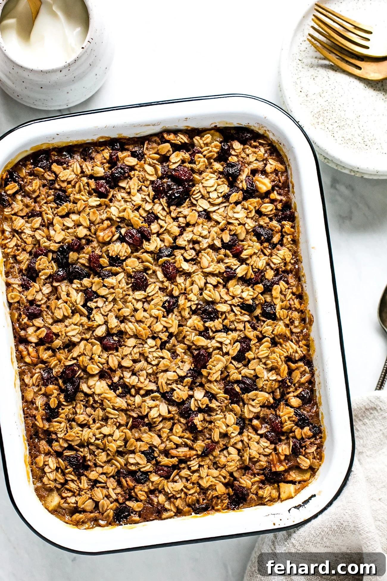 Comforting Apple Raisin Oatmeal Bake 9 A freshly baked, golden-brown Apple & Raisin Baked Oatmeal, still warm in the baking dish, featuring a perfectly set top and visible fruit.