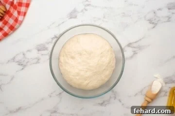 Spinach Pizza 7 Pizza dough in clear bowl after doubling in size.
