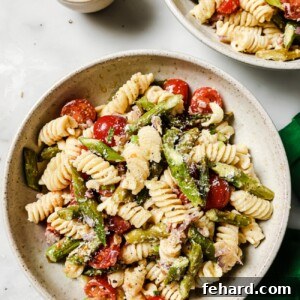 A close-up view of a serving of Asparagus Pasta Salad, garnished and ready.