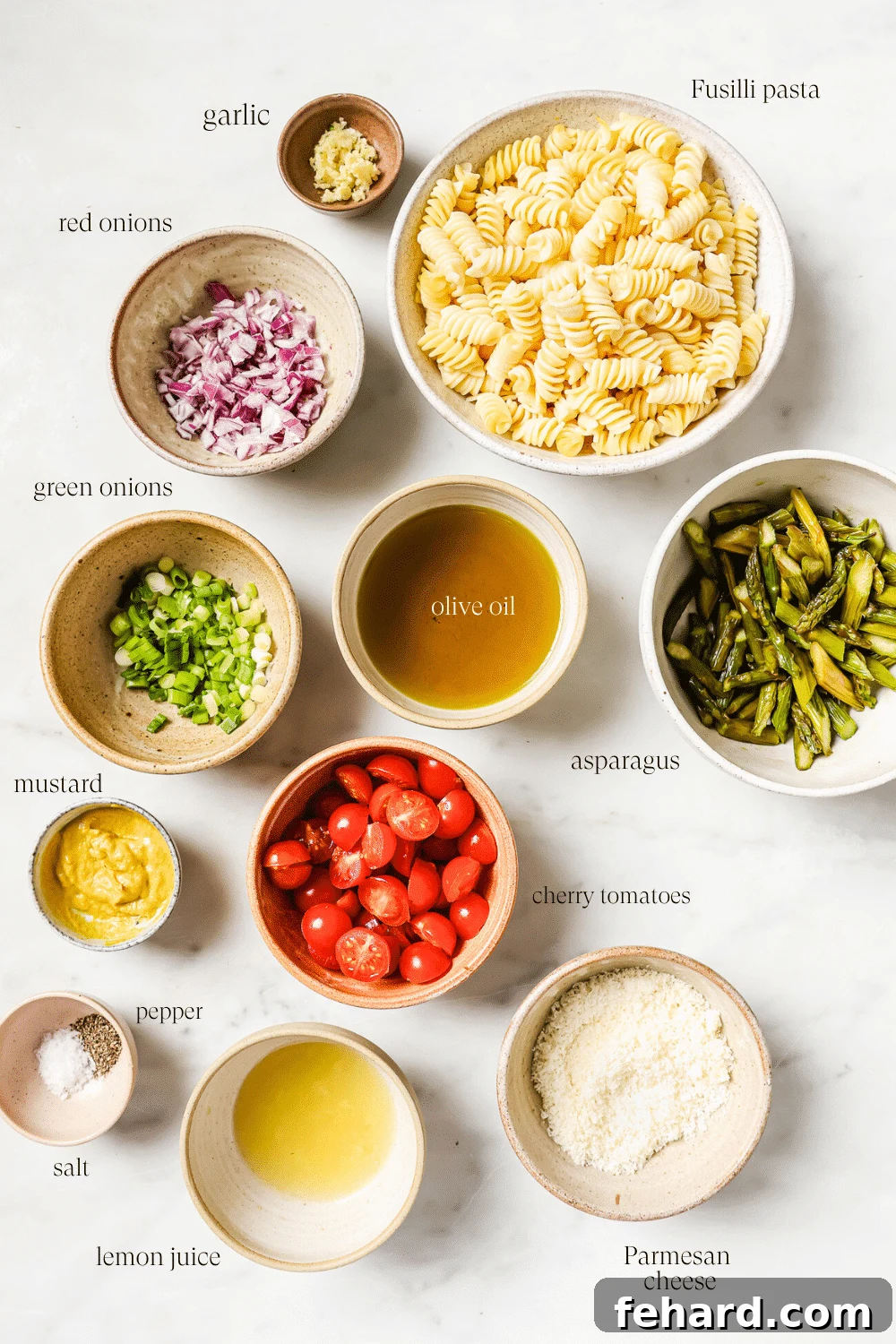 Vibrant Asparagus Pasta Salad 3 Small bowls containing pre-measured ingredients for the asparagus pasta salad, including pasta, roasted asparagus, cherry tomatoes, red onion, green onion, Parmesan cheese, olive oil, lemon juice, Dijon mustard, and garlic.
