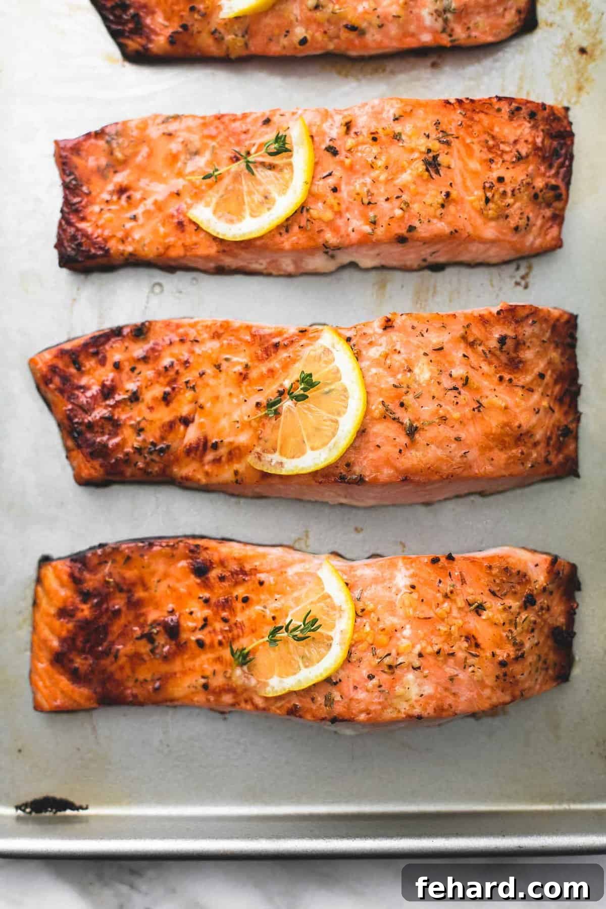 Any Night Salmon Dinner Recipes Baked Pan Seared or Broiled 4 Three perfectly baked fish fillets arranged on a baking sheet, ready to serve.