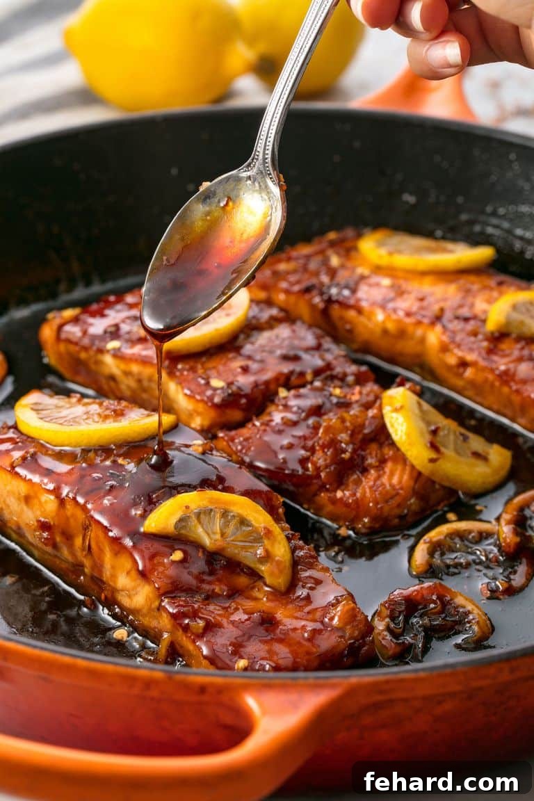 Any Night Salmon Dinner Recipes Baked Pan Seared or Broiled 7 An overhead view of a cast iron skillet filled with delectable honey garlic salmon.