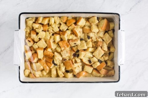 Assembled casserole covered in plastic wrap.