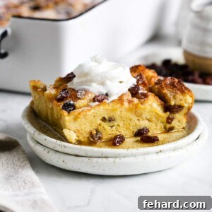 A piece of casserole with whipped topping on a small white plate.