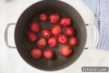 Saucepan filled with red potatoes and water, ready for boiling.