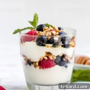 Closeup view of a vibrant Yogurt Parfait with layers of fruit and granola.
