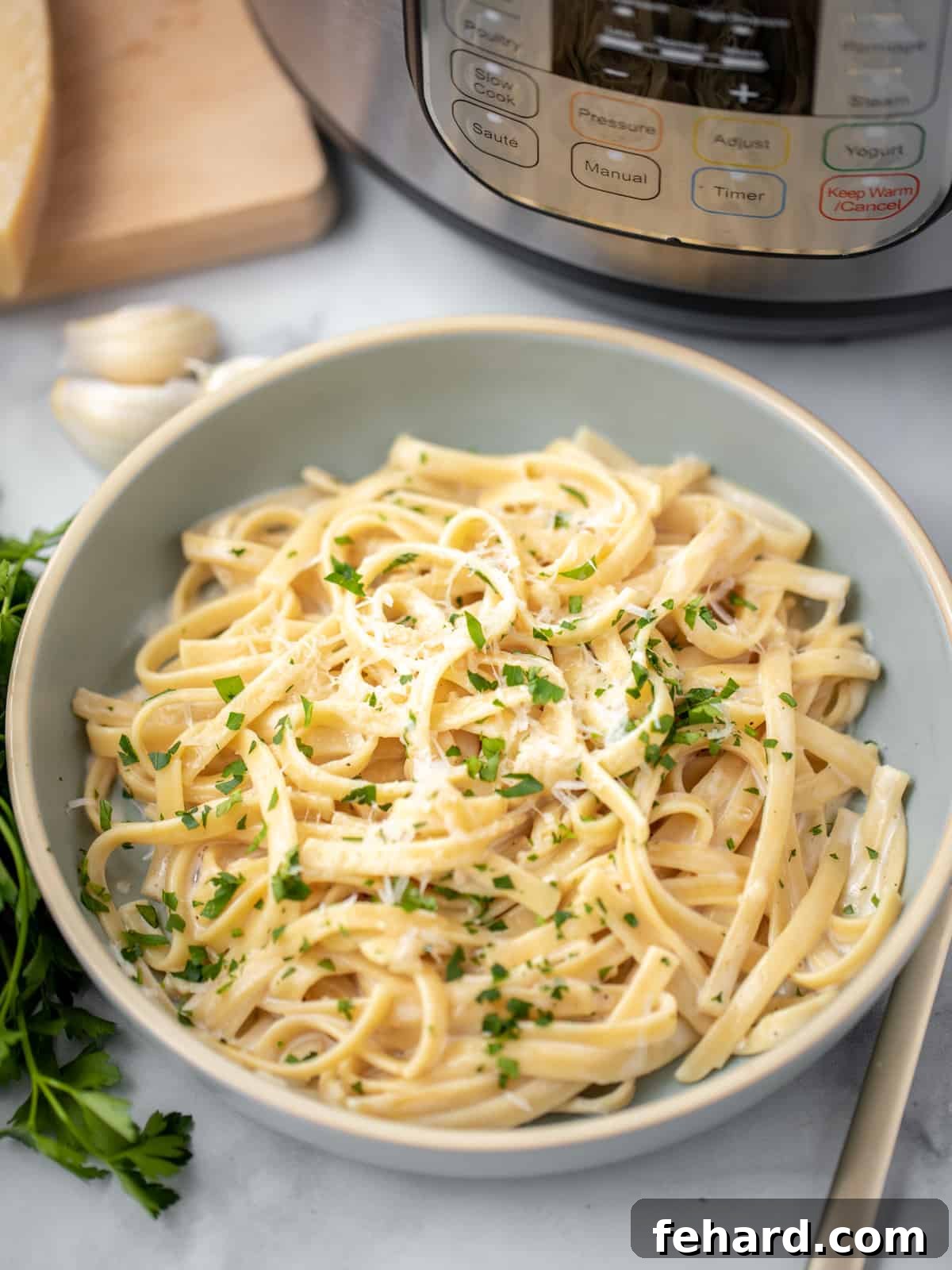 Instant Pot Fettuccine Alfredo Recipe - Quick and Creamy A steaming bowl of Instant Pot Fettuccine Alfredo, garnished with fresh parsley, sitting beside an Instant Pot, inviting a delicious meal.