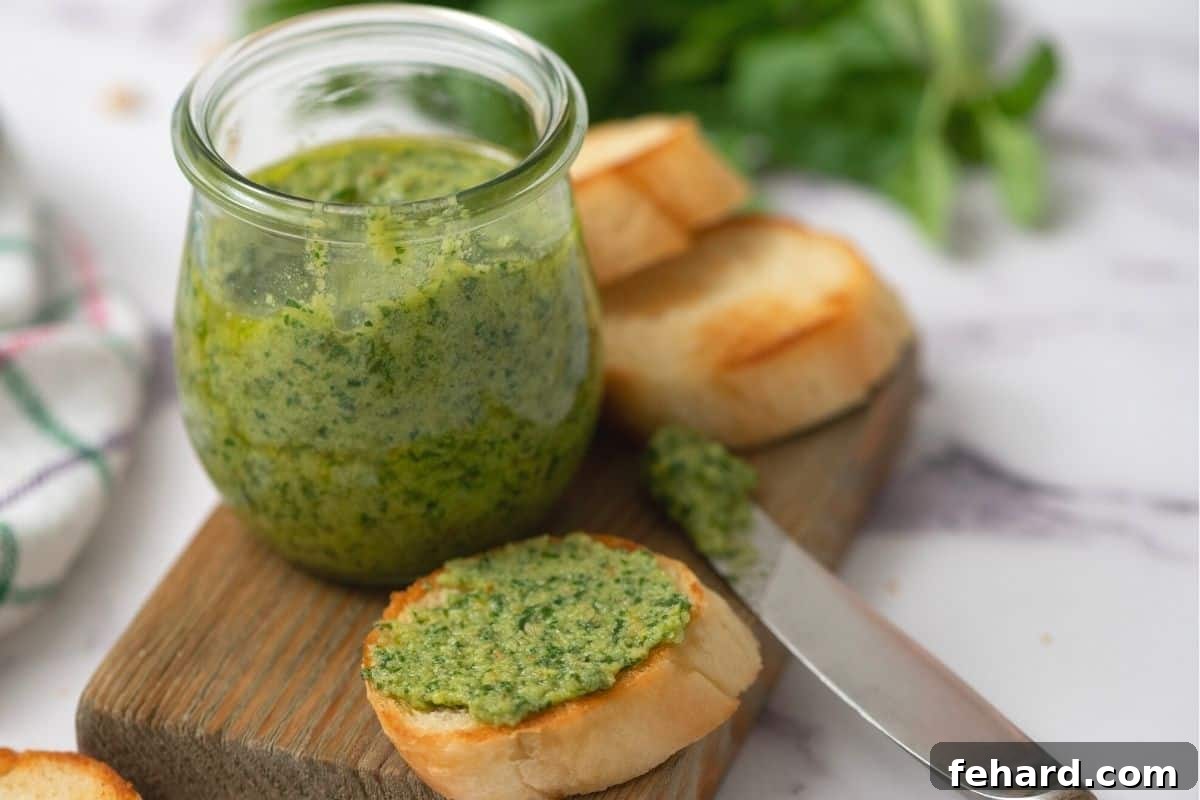 Basil Pesto spread on toasted baguette slices, presented next to a jar of fresh pesto sauce.