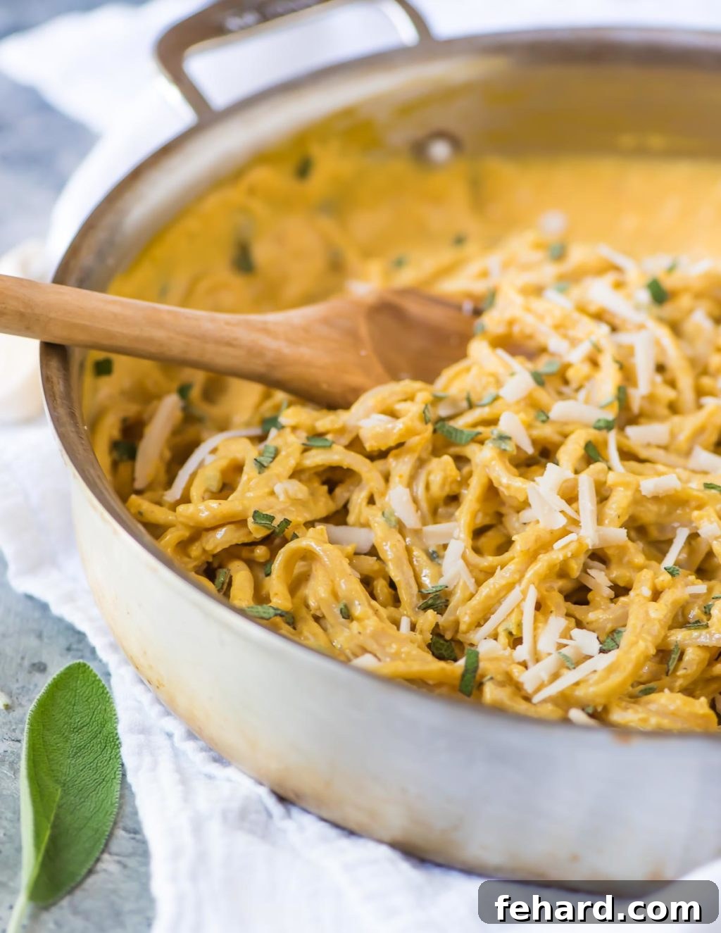 A large skillet brimming with fettuccine noodles tossed in a luscious creamy pumpkin sauce, exquisitely topped with grated parmesan cheese and fresh herbs.