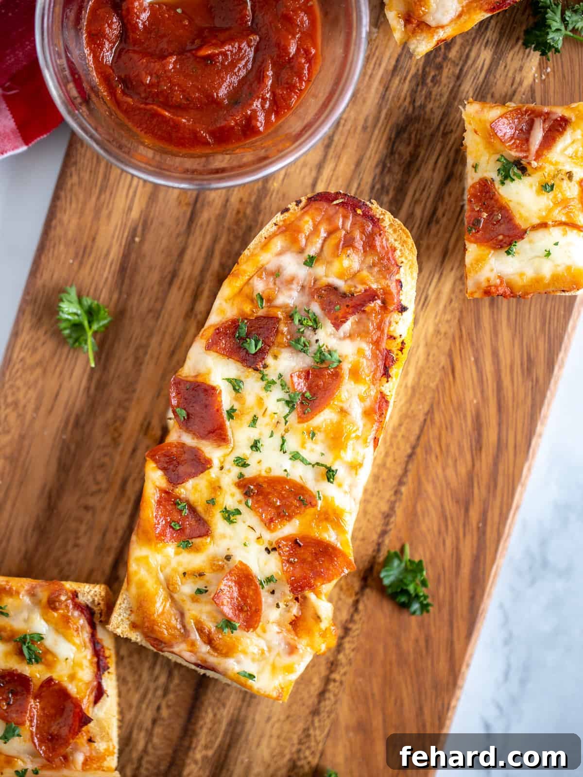Crispy Air Fryer French Bread Pizza topped with pepperoni, freshly cooked and ready to serve on a rustic cutting board.