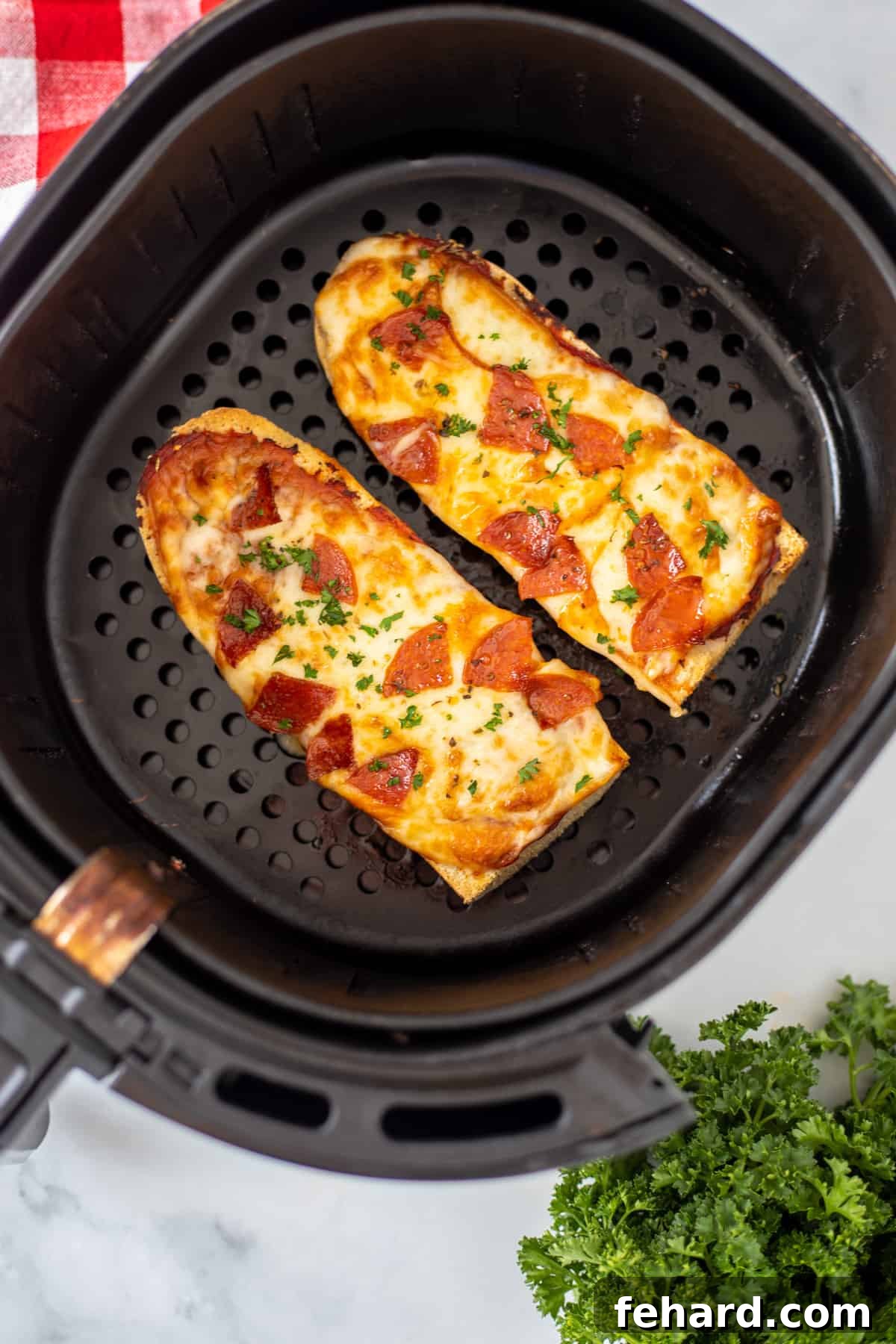 Freshly cooked Air Fryer French Bread Pizza with perfectly melted cheese and pepperoni, removed from the air fryer and ready to be enjoyed, displayed on a wooden cutting board.