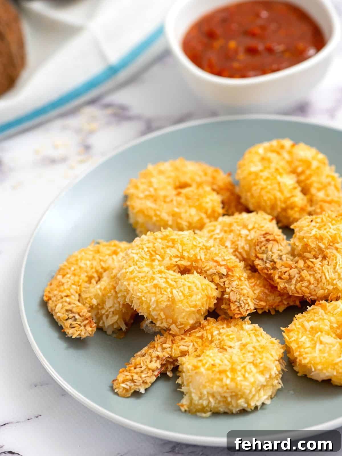 Delicious Baked Coconut Shrimp served on a vibrant blue plate, garnished for a fresh presentation.