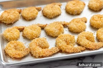 Baked breaded shrimp on a sheet pan, perfectly golden and crispy.