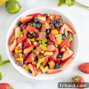 Summer fruit tossed together in serving dish topped with mint.