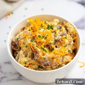 Bowl of Bacon Ranch Potato Salad topped with chives.