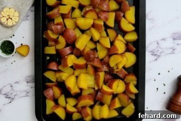 Boiled Red potatoes on baking sheet cooling after cooking.