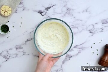 Sour cream, mayonnaise and ranch seasoning mixed together in large mixing bowl.